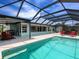 Beautiful screened pool with outdoor living space, barbecue, and lush landscaping at 18302 Burkholder Cir, Port Charlotte, FL 33948