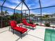 Waterfront screened pool with lounge chairs that offer peaceful canal views at 18302 Burkholder Cir, Port Charlotte, FL 33948