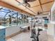 Sunroom with woven ceiling, exercise equipment, and views of pool and canal at 18302 Burkholder Cir, Port Charlotte, FL 33948