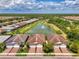 An aerial perspective of a neighborhood showcasing well-maintained lawns, and a tranquil pond with a fountain at 20636 Swallowtail Ct, Venice, FL 34293