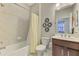 Bathroom featuring a tub with shower, a vanity with a dark wood cabinet, and decorative wall accents at 20636 Swallowtail Ct, Venice, FL 34293
