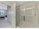 Bright bathroom with tile shower and glass door, open to bedroom at 20636 Swallowtail Ct, Venice, FL 34293