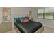 Bedroom featuring a bed with stylish pillows, neutral walls, and a view through the window at 20636 Swallowtail Ct, Venice, FL 34293