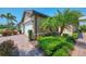 Home's exterior featuring colorful landscaping, paver driveways and sidewalks and a garage, creating charm at 20636 Swallowtail Ct, Venice, FL 34293
