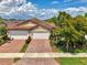 Charming home featuring a paver driveway, two-car garage, and lush landscaping, creating curb appeal at 20636 Swallowtail Ct, Venice, FL 34293