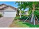 Elegant front entrance with dark door, stylish exterior lighting, and lush landscaping for an inviting curb appeal at 20636 Swallowtail Ct, Venice, FL 34293