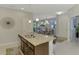 Kitchen island with stainless steel sink, granite countertops, seating for three, and tile floors at 20636 Swallowtail Ct, Venice, FL 34293