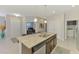 Kitchen island with stainless steel dishwasher, granite countertops, brown cabinets, and tile floors at 20636 Swallowtail Ct, Venice, FL 34293