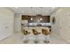 Kitchen island with stainless steel appliances, pendant lighting, three bar stools, and tile floors at 20636 Swallowtail Ct, Venice, FL 34293