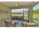Cozy screened lanai with comfortable seating and tranquil lake view at 20636 Swallowtail Ct, Venice, FL 34293