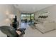 Living area with comfortable seating and a screened-in porch overlooking a lake at 20636 Swallowtail Ct, Venice, FL 34293