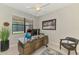 Well-lit office featuring a ceiling fan, large window with blinds, and a contemporary wooden desk with a glass top at 20636 Swallowtail Ct, Venice, FL 34293