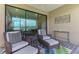 Relaxing patio with wicker seating and a view of the surrounding landscaping at 20636 Swallowtail Ct, Venice, FL 34293
