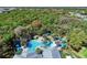 Aerial view highlights a luxurious community pool with palm trees, cabanas, and a black-and-white tiled patio at 21057 Anclote Ct, Venice, FL 34293