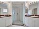 Bathroom with dual vanities, a glass-enclosed shower, and modern fixtures at 212 Triano Cir # 212, Venice, FL 34292