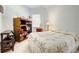 Comfortable bedroom features a charming quilt, a large bookcase, and a window with natural light at 212 Triano Cir # 212, Venice, FL 34292