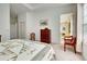 Bedroom with neutral decor, features a chest, and a chair to access the relaxing balcony at 212 Triano Cir # 212, Venice, FL 34292