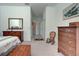A well-lit bedroom with a hallway view shows a dresser, chair, and comfortable furnishings at 212 Triano Cir # 212, Venice, FL 34292