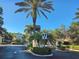 Well-maintained community entrance featuring mature palm trees and lush landscaping with beautiful signage at 212 Triano Cir # 212, Venice, FL 34292