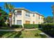 Exterior corner view featuring a garden-style home with lush landscaping, a sidewalk, and well-placed windows at 212 Triano Cir # 212, Venice, FL 34292