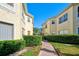 Exterior view of well-maintained townhomes with neat landscaping and a paved walkway at 212 Triano Cir # 212, Venice, FL 34292