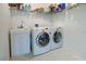 Functional laundry room with washer, dryer, utility sink, and ample shelving for storage at 212 Triano Cir # 212, Venice, FL 34292