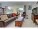 Cozy living room featuring a leather sofa, decorative pillows, and sliding glass doors to the patio at 212 Triano Cir # 212, Venice, FL 34292