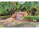 Scenic waterfall feature surrounded by lush greenery, gravel, and rocks creating a natural oasis at 212 Triano Cir # 212, Venice, FL 34292