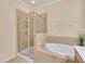 Bathroom featuring a glass-enclosed shower and a soaking tub at 2150 Snapdragon Ln, Venice, FL 34292