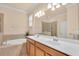 Bathroom featuring double sinks, a soaking tub, and a glass enclosed shower at 2150 Snapdragon Ln, Venice, FL 34292