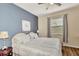 Cozy bedroom featuring a blue accent wall, comfortable bedding, and a window with natural light at 2150 Snapdragon Ln, Venice, FL 34292