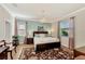 Elegant bedroom featuring a chandelier, large bed, and windows offering natural light at 2150 Snapdragon Ln, Venice, FL 34292
