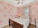 Charming bedroom with pink patterned walls, a cozy bed, and natural light from the window at 2150 Snapdragon Ln, Venice, FL 34292