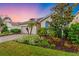 A well-maintained single-Gathering home with a brick driveway, an attached two-car garage, and a beautifully landscaped front yard at 2150 Snapdragon Ln, Venice, FL 34292