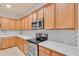A modern kitchen with stainless steel oven, white countertop, and light-colored cabinets with white patterned backsplash at 2150 Snapdragon Ln, Venice, FL 34292