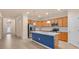 A modern kitchen featuring stainless steel appliances, white countertops, and an island with a blue accent at 2150 Snapdragon Ln, Venice, FL 34292