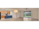 Spacious and well-lit living area open to the kitchen, featuring a sliding glass door and a ceiling fan at 2150 Snapdragon Ln, Venice, FL 34292