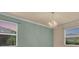 Bright living space with a chandelier and view of the lush landscaping through the two windows at 2150 Snapdragon Ln, Venice, FL 34292