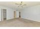 Spacious bedroom with neutral carpet, ceiling fan, and doorways to bathroom and closet at 232 Saint Augustine Ave # 505, Venice, FL 34285
