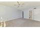 Spacious bedroom with neutral carpet, ceiling fan, and doorways to bathroom and closet at 232 Saint Augustine Ave # 505, Venice, FL 34285