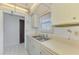 Kitchen featuring stainless steel double sink, cream countertops, and white cabinets at 232 Saint Augustine Ave # 505, Venice, FL 34285