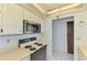 Kitchen featuring an electric stove, microwave, cream countertops, and white cabinets at 232 Saint Augustine Ave # 505, Venice, FL 34285