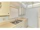 A well-lit kitchen with a stainless steel double sink, cream countertops, and white cabinets at 232 Saint Augustine Ave # 505, Venice, FL 34285