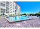 Community pool with brick paver surround with lounge chairs and clear blue sky at 232 Saint Augustine Ave # 505, Venice, FL 34285