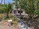 Secluded backyard garden featuring a stone pathway, mature trees, and lush greenery offering a tranquil retreat at 2331 Mission Valley Blvd, Nokomis, FL 34275