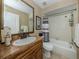 Bathroom featuring vanity sink with bronze faucet, tub and shower with neutral tile at 2331 Mission Valley Blvd, Nokomis, FL 34275