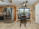 Cozy dining area featuring stainless steel refrigerator and a charming table with chairs at 2331 Mission Valley Blvd, Nokomis, FL 34275