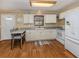 Well-lit kitchen with white cabinets, modern appliances, wood floors, and a cozy dining area for casual meals at 2331 Mission Valley Blvd, Nokomis, FL 34275