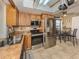 Bright kitchen featuring stainless steel appliances, light wood cabinets, and a cozy dining area at 2331 Mission Valley Blvd, Nokomis, FL 34275
