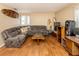 Comfortable living room featuring hardwood floors, a plush gray sectional sofa, and unique decor elements at 2331 Mission Valley Blvd, Nokomis, FL 34275